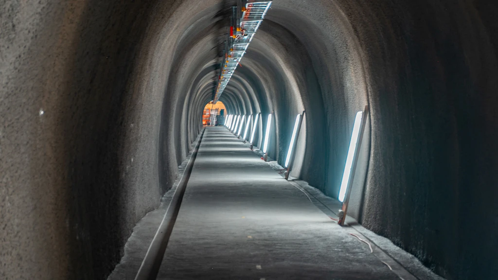 Langer Tunnel mit beleuchteten Wänden und glattem Boden, der sich perspektivisch verjüngt